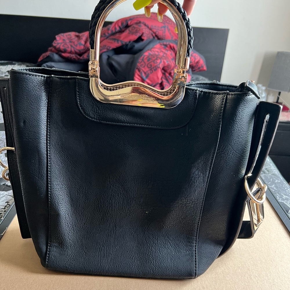 Large black handbag with gold handles and leopard print lining.